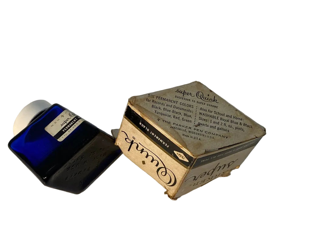 A vintage blue glass ink bottle next to its original cardboard box, both labeled 'Cowell Super Quink'.