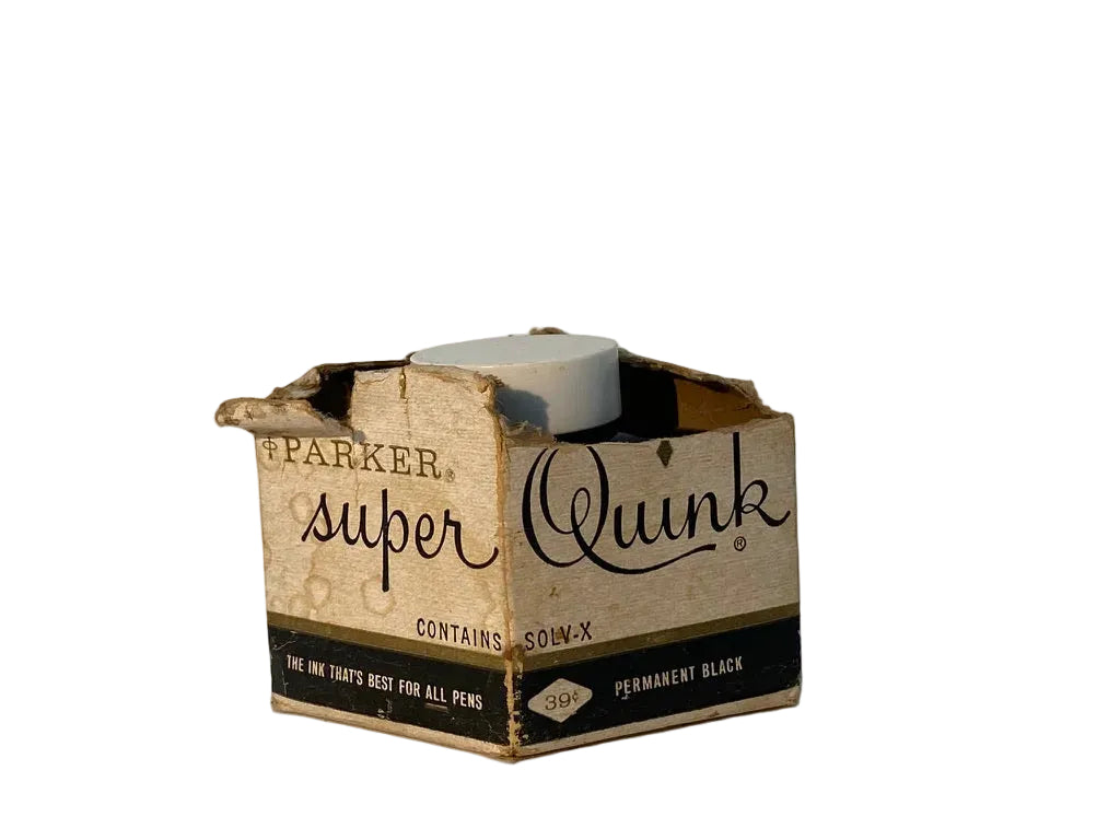 Vintage Parker Super Quink Sou-X permanent black ink bottle in its original cardboard packaging, photographed on a neutral light gray background.