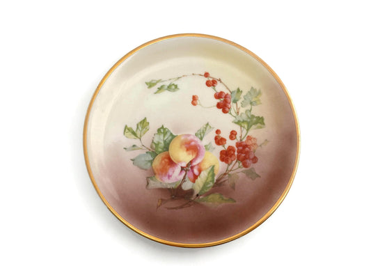 Decorative plate with floral and fruit design on a white background
